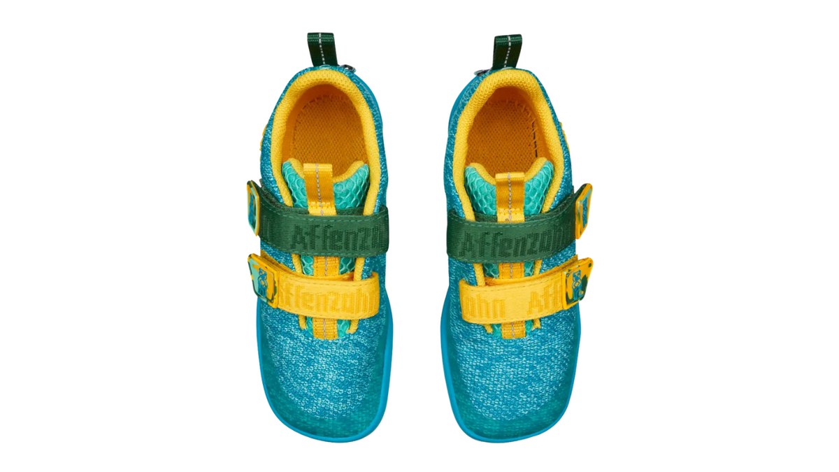 Kinder-Barfußschuh als Paar mit breiter Zehenbox, geschlossenem Zehenbereich, geschlossenem Fersenbereich, Klettverschluss, flexible Sohle, Draufsicht.