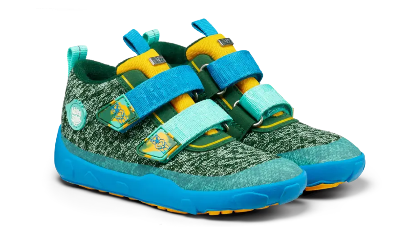Kinder-Barfußschuh mit breiter Zehenbox, geschlossenem Zehenbereich, geschlossenem Fersenbereich, Klettverschluss, flexible Sohle, schräge Vorderansicht.