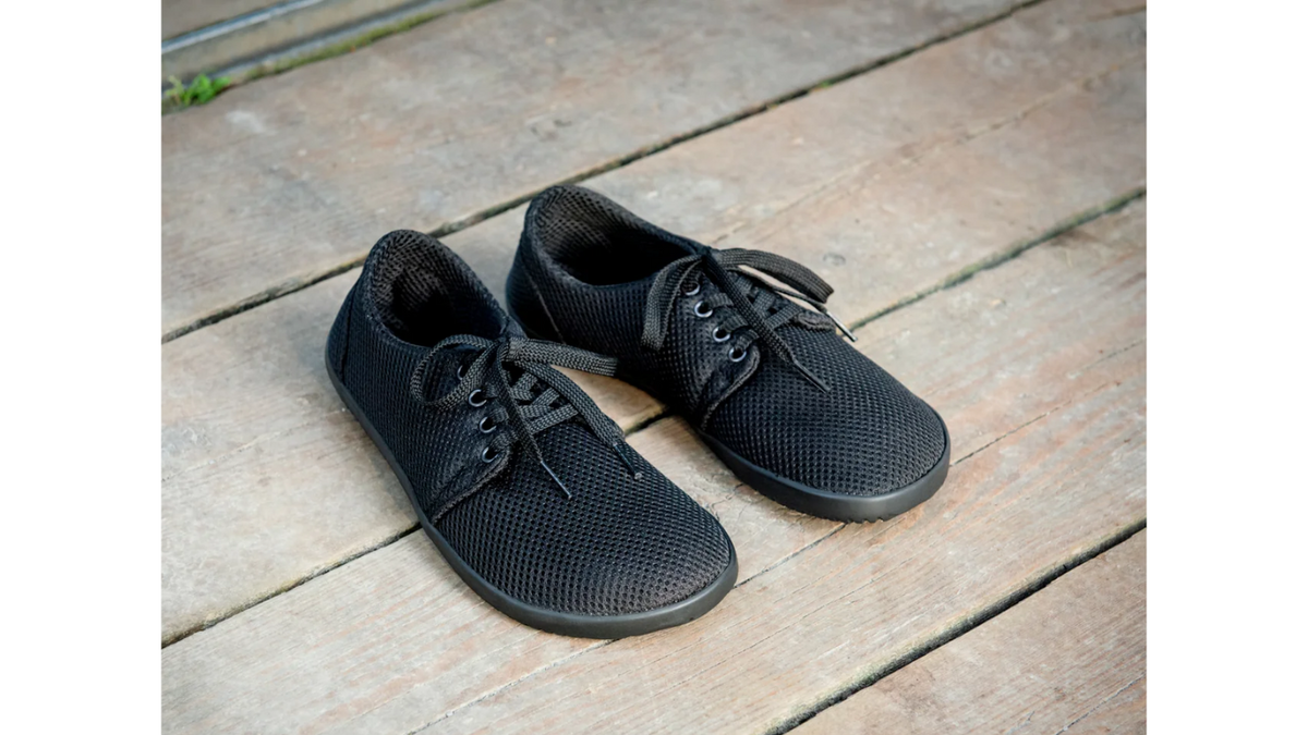 arfußschuhe im getragenen Zustand, Draufsicht leicht schräg. Geschlossene Zehen, flache Sohle, bodennaher Stand.