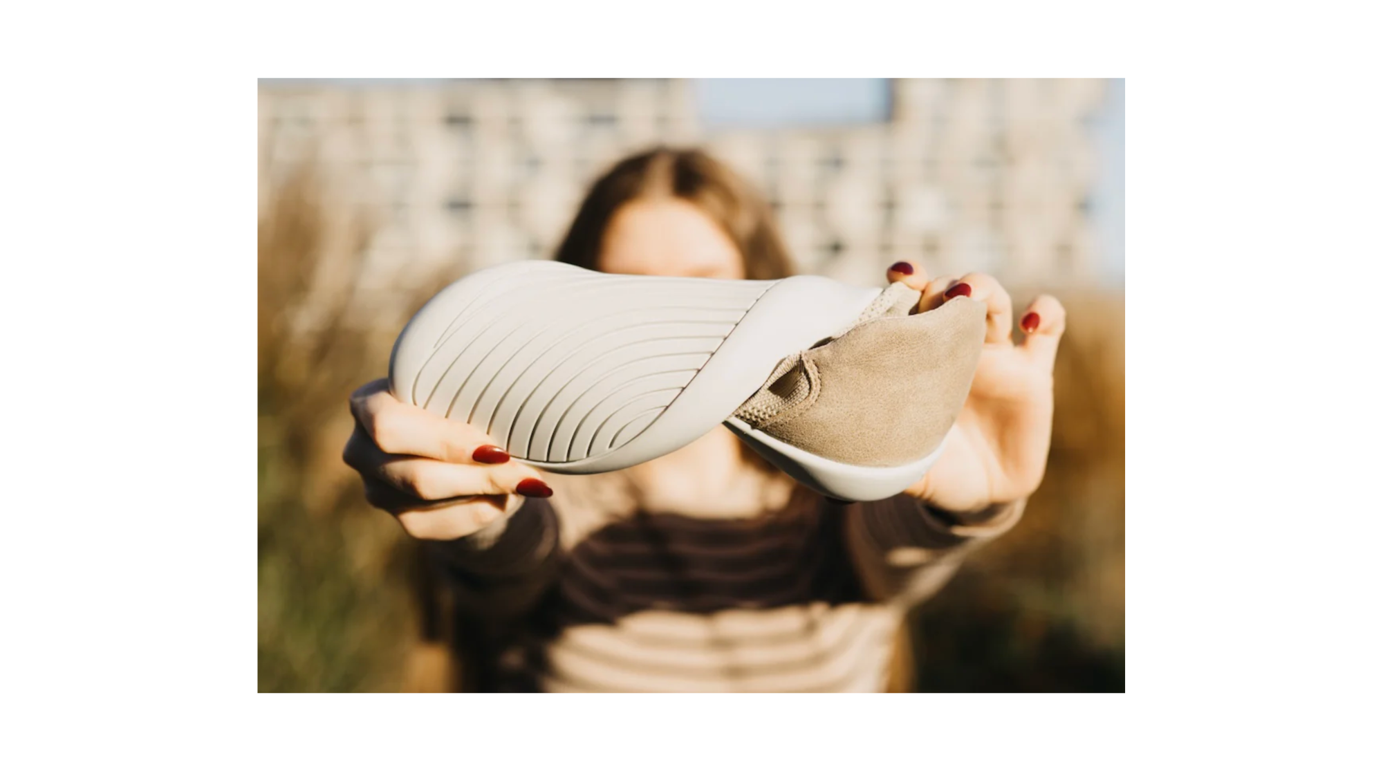 Barfußschuh mit flexibler Sohle in Ansicht von unten, gehalten und gebogen von einer Person