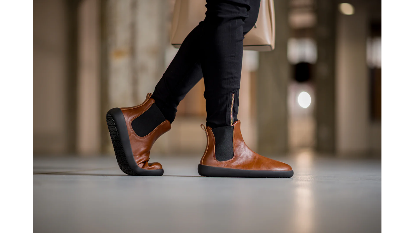 Barfußschuh Chelsea, Seitenansicht außen. Getragener knöchelhoher Schuh im Schritt, geschlossener Fersenbereich sichtbar.