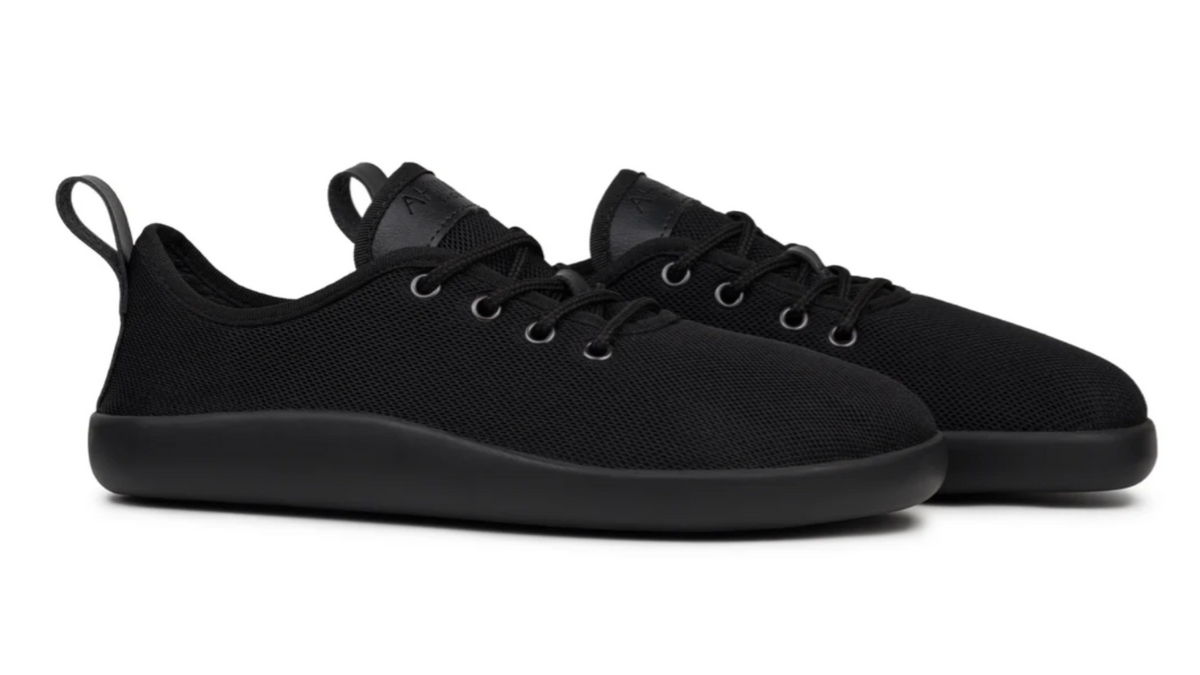 Barfußschuh, flache geschlossene Ausführung, schräge Vorderansicht als Paar. Runde Zehenform, bodennahe Konstruktion.