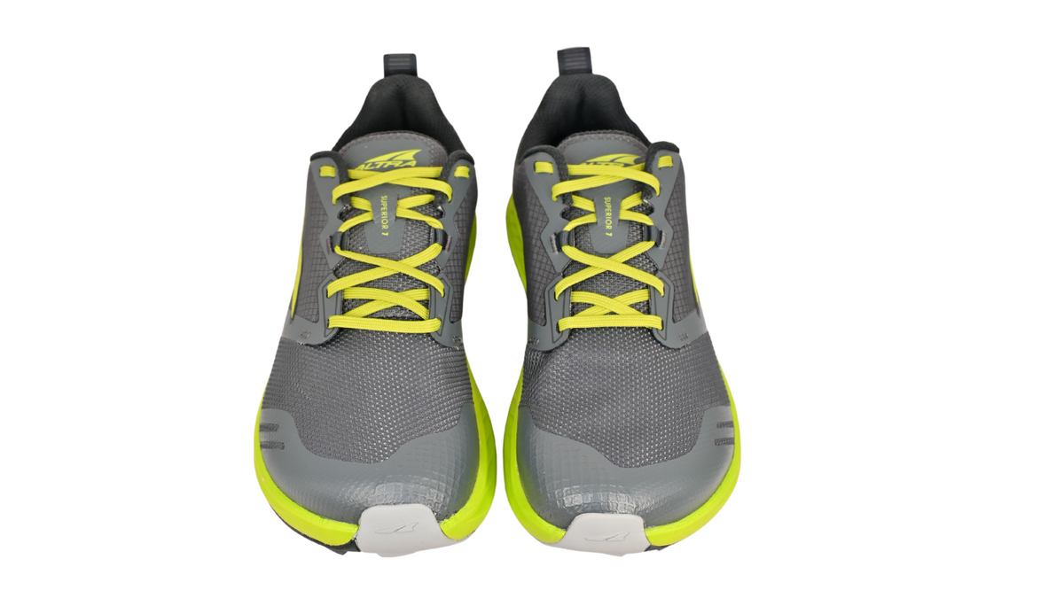 Laufschuhe als Paar, Frontansicht. Symmetrische Schnürung, gleichmäßige Zehenform.