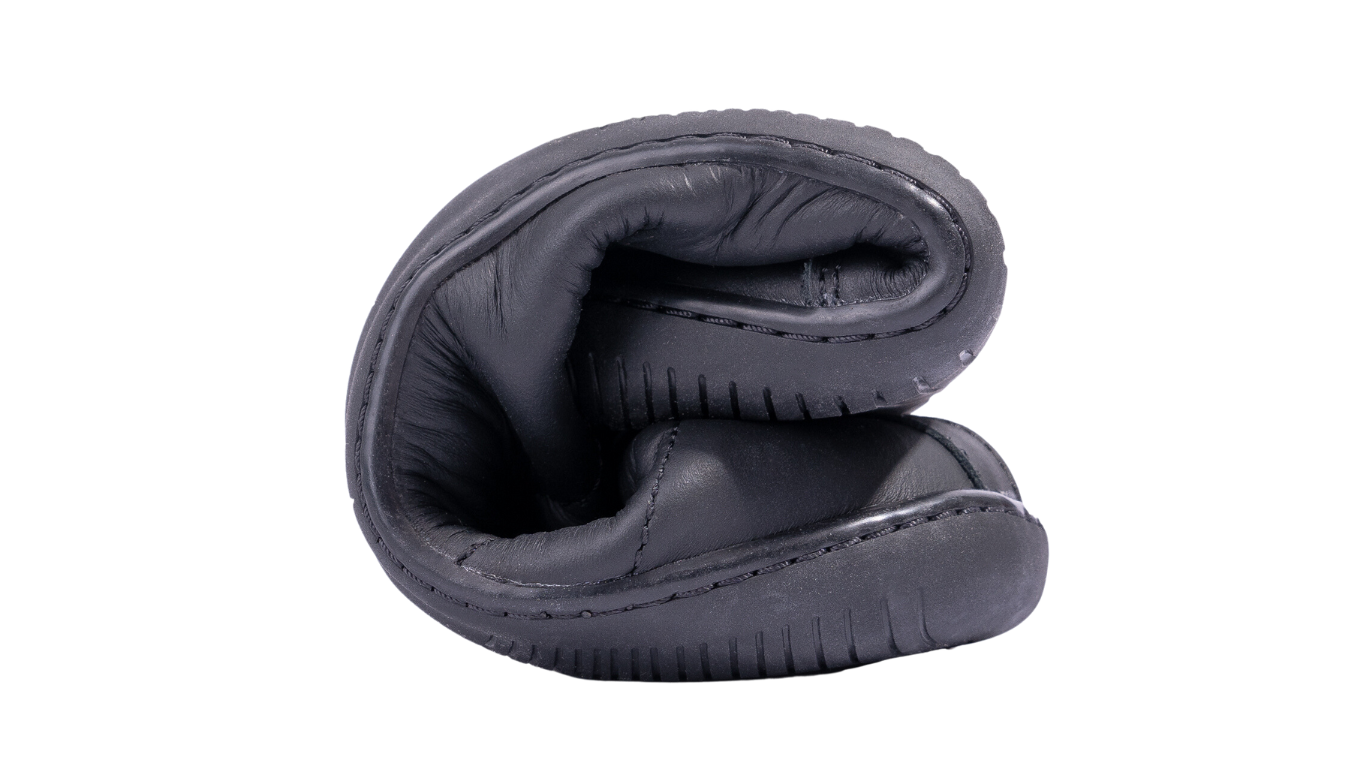 Barfußschuh, Detailansicht. Zusammengerollter Schuh mit sichtbar flexibler Sohle.