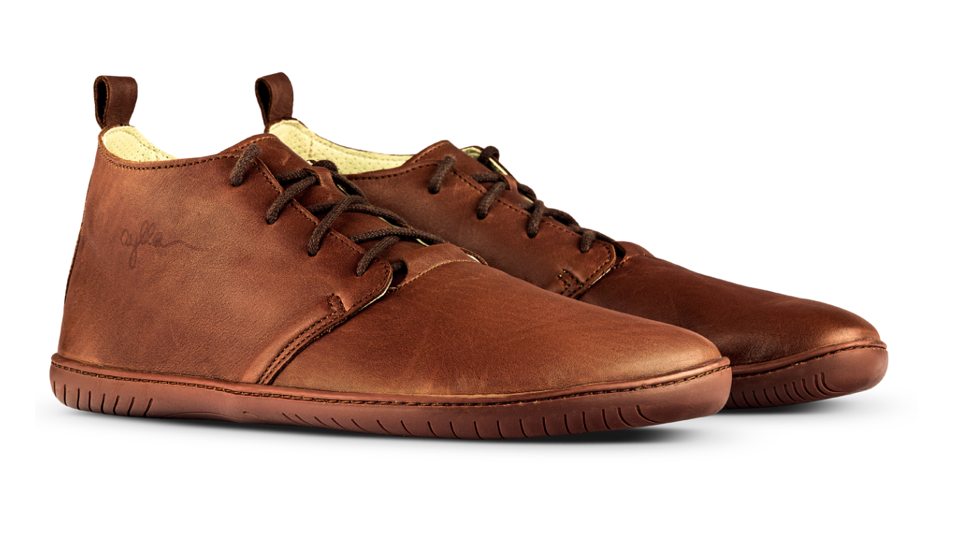 Barfußstiefel als Paar, schräge Vorderansicht. Geschlossener Schuh mit Schnürung, gleichmäßige Sohlenhöhe, symmetrische Form.