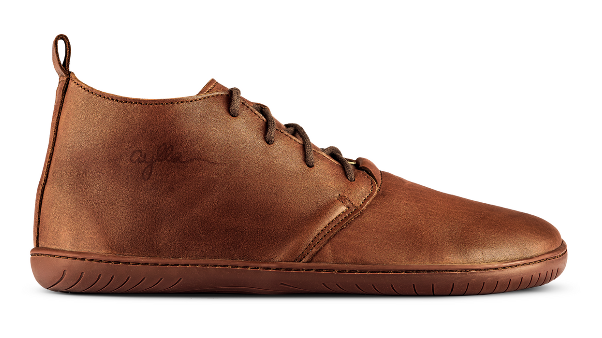 Barfußstiefel, Seitenansicht außen. Geschlossener Schuh mit Schnürung, mittelhoher Schaft, breite Zehenbox, flexible flache Sohle.