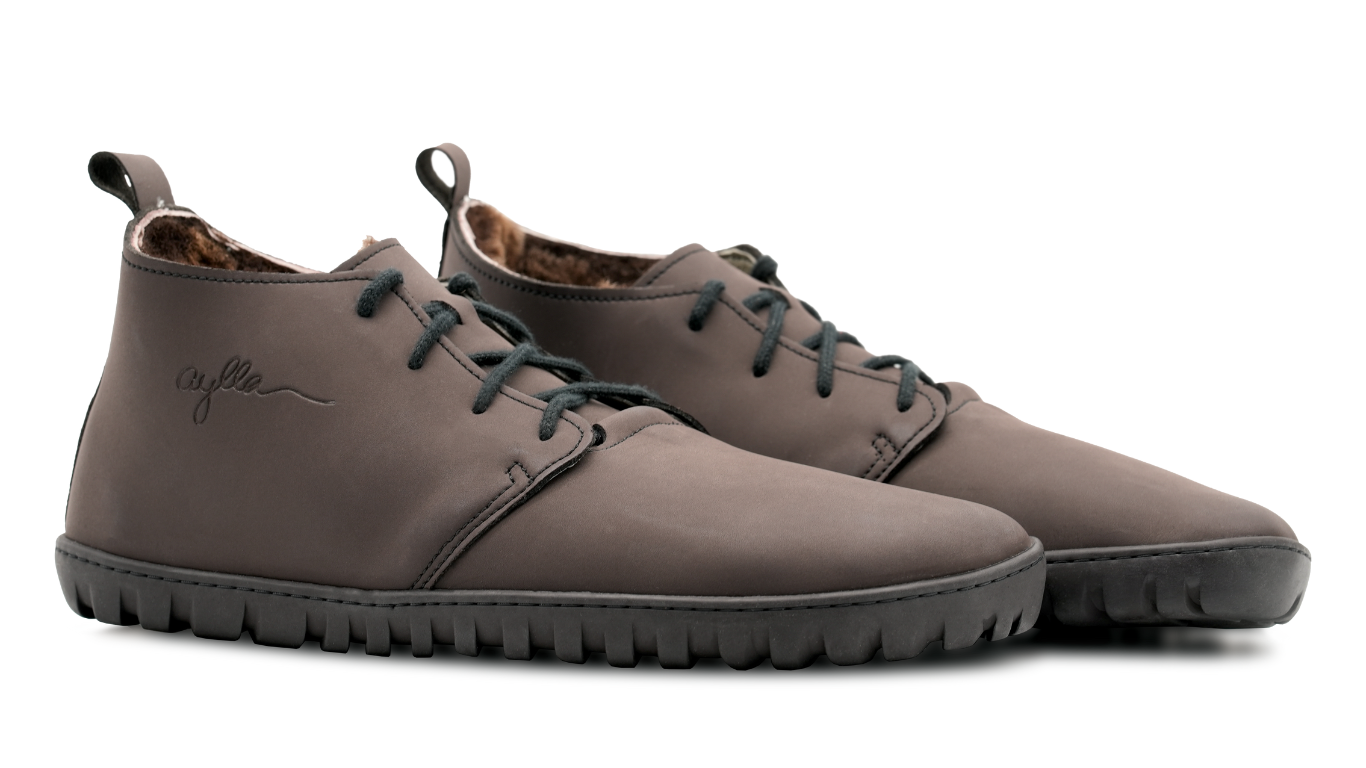Barfußstiefel als Paar, schräge Vorderansicht. Geschlossener Schuh, Schnürung, symmetrische Form, gleichmäßige Sohlenhöhe.