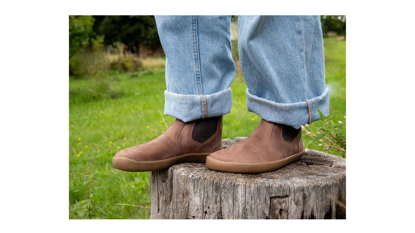 Knöchelhoher Barfußschuh im getragenen Zustand, Seitenansicht außen. Natürlicher Stand, flache Sohle, knöchelhoher Schaft.