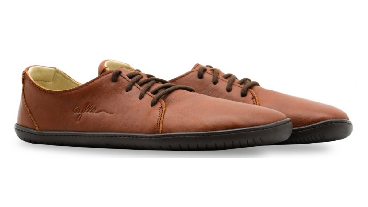 Barfußschuh für Erwachsene als Paar mit breiter Zehenbox, geschlossenem Zehenbereich, geschlossener Ferse, Schnürung, flacher flexible Sohle, schräge Vorderansicht.