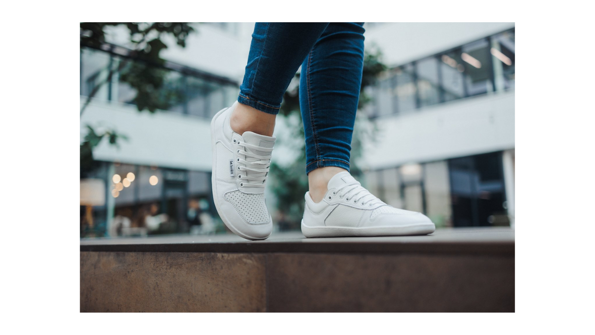 Barfußschuh Sneaker am Fuß getragen, flexible Sohle, geschlossene Zehen, geschlossener Fersenbereich, schräge Vorderansicht