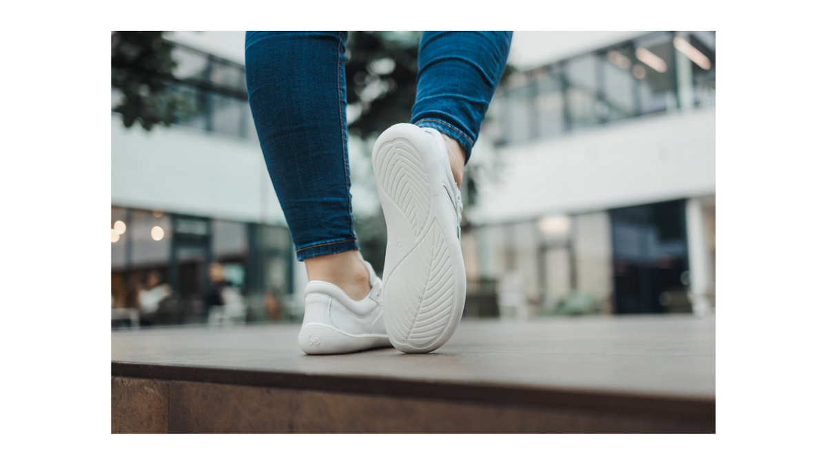 Barfußschuh Sneaker am Fuß getragen, flexible Sohle sichtbar, geschlossene Zehen, geschlossener Fersenbereich, Ansicht von unten
