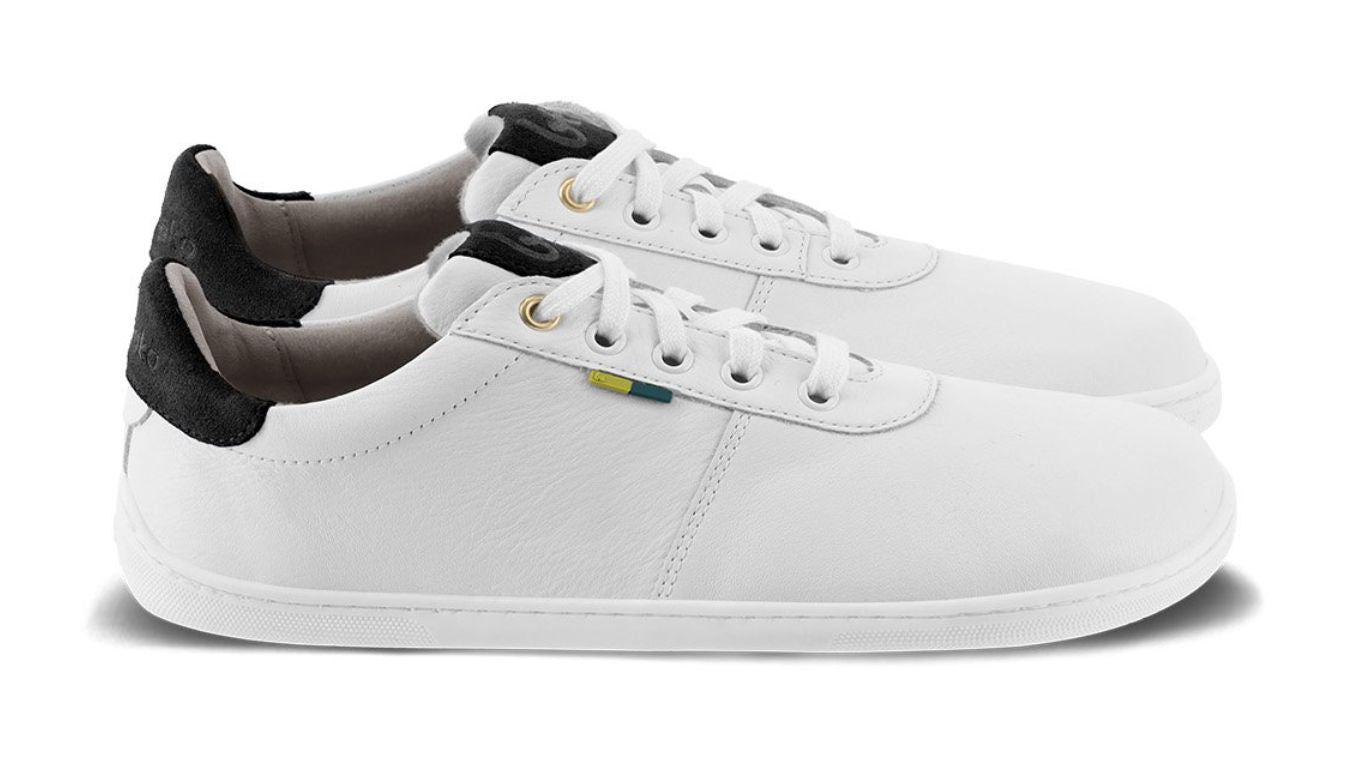 Barfußschuh Sneaker als Paar mit breiter Zehenbox und flacher Sohle, schräge Vorderansicht.