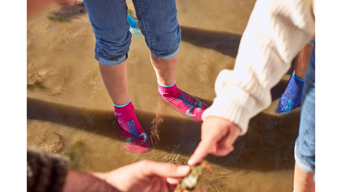 Wassersocke für Kinder mit flexibler Sohle und geschlossenen Zehen, Seitenansicht außen am Fuß getragen.