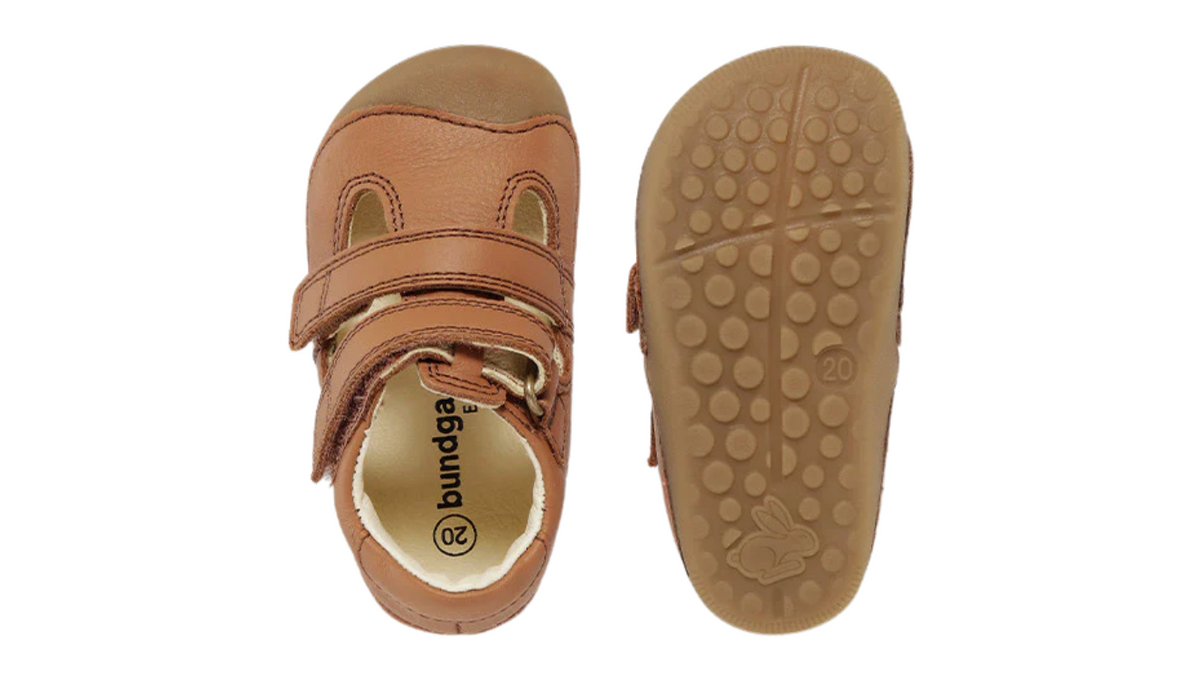 Kinder-Barfußschuh mit breiter Zehenbox, geschlossenem Zehenbereich, geschlossenem Fersenbereich, Riemenkonstruktion mit Verschluss, flacher flexibler Sohle, Draufsicht und Ansicht von unten.