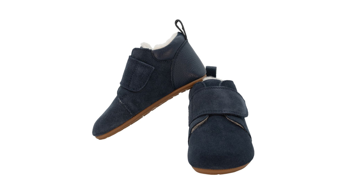 Kinder-Barfußschuh mit breiter Zehenbox, geschlossenem Zehenbereich, geschlossenem Fersenbereich, Klettverschluss, flacher flexibler Sohle, schräge Vorderansicht.