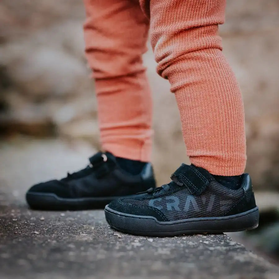 Barfußschuh für Kinder am Fuß getragen, mit Klettverschluss und Schnürung, breite Zehenbox erkennbar, geschlossene Zehen und Ferse, Seitenansicht außen