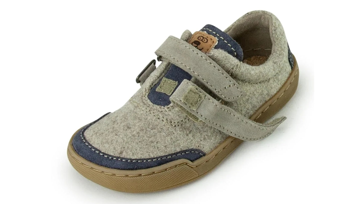 Barfußschuh für Kinder mit geschlossener Zehenbox, zwei Klettverschlüssen und breiter Zehenbox. Schräge Vorderansicht.