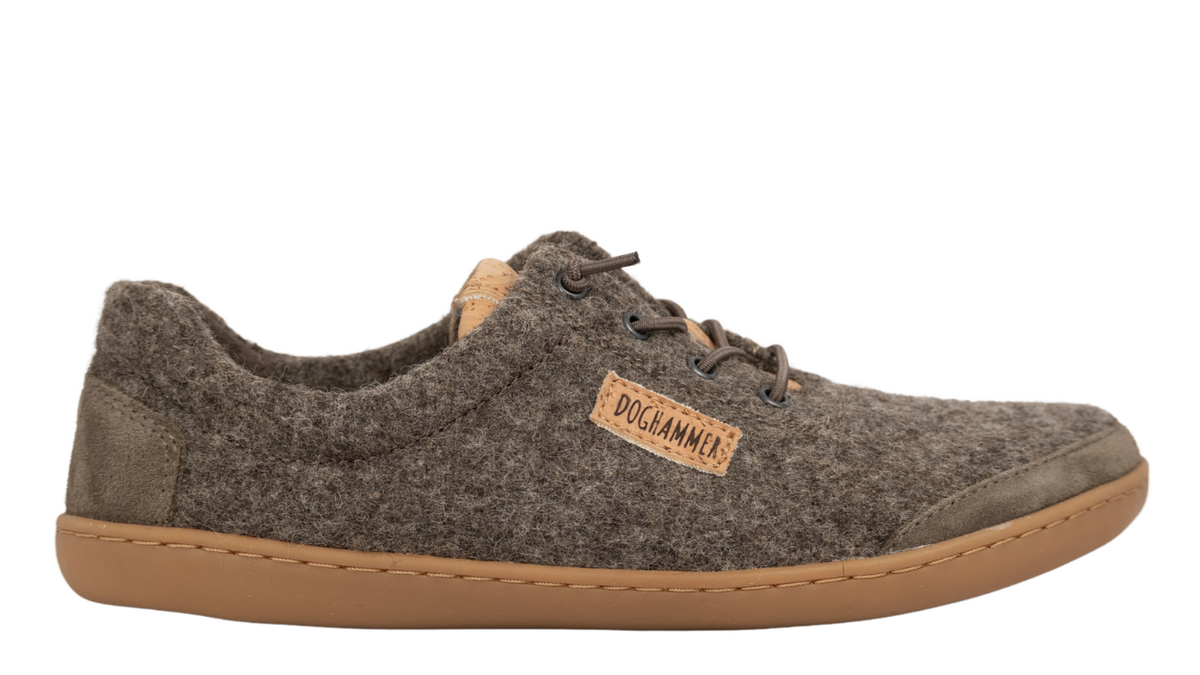 Barfußschuh für Erwachsene mit geschlossener Zehenbox, Schnürung und flacher, flexibler Sohle. Obermaterial aus grauem Filz. Seitenansicht außen.