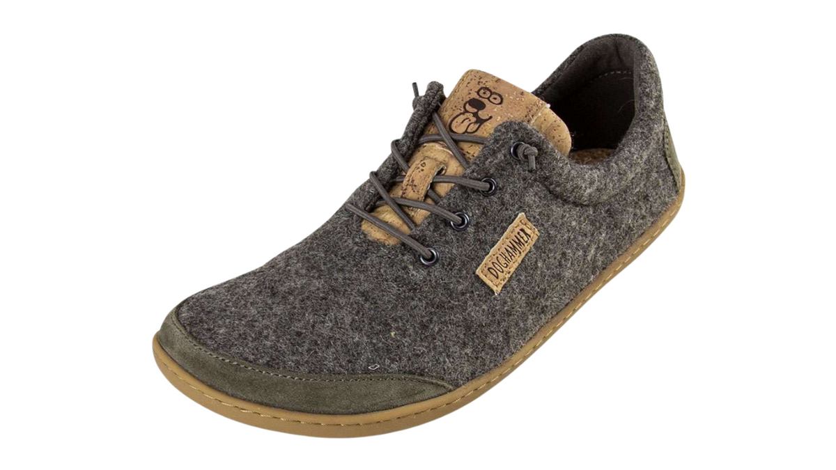 Barfußschuh für Erwachsene mit geschlossener Zehenbox, Schnürung und flacher Sohle. Graues Wool-Obermaterial. Schräge Vorderansicht.