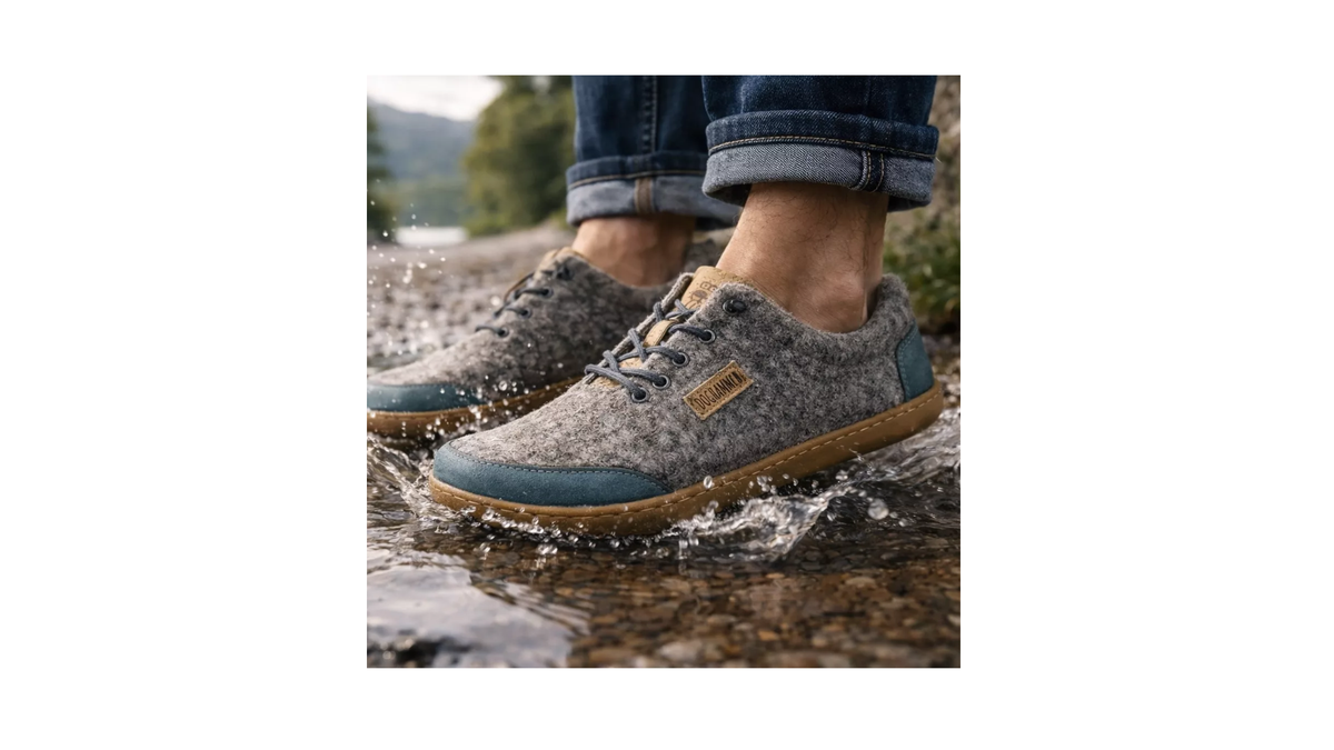 Barfußschuh für Erwachsene mit geschlossener Zehenbox, Schnürung und flacher, flexibler Sohle. Getragen am Fuß, schräge Seitenansicht außen