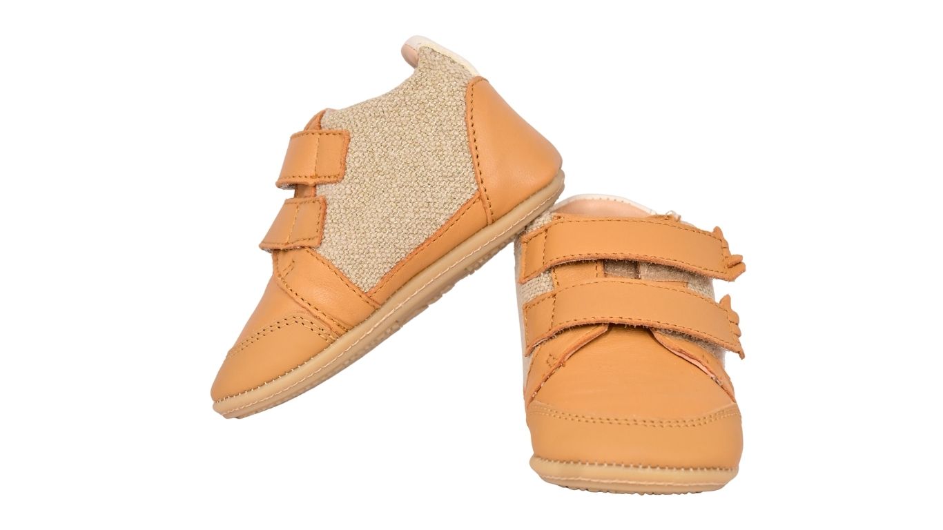Kinder-Barfußschuh mit breiter Zehenbox, Klettverschluss und flexibler Sohle. Schräge Vorderansicht.