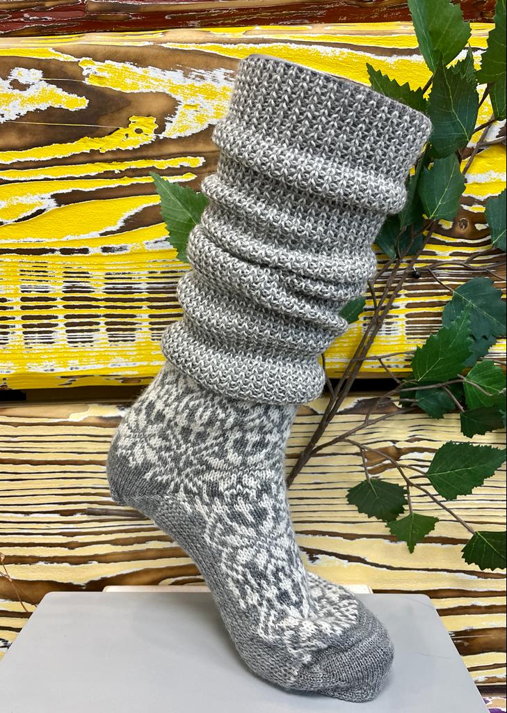 Socken ohne separate Zehen, knielanger Schaft, elastischer Bund, gemustertes Schaftteil, getragen am Fuß, Seitenansicht außen