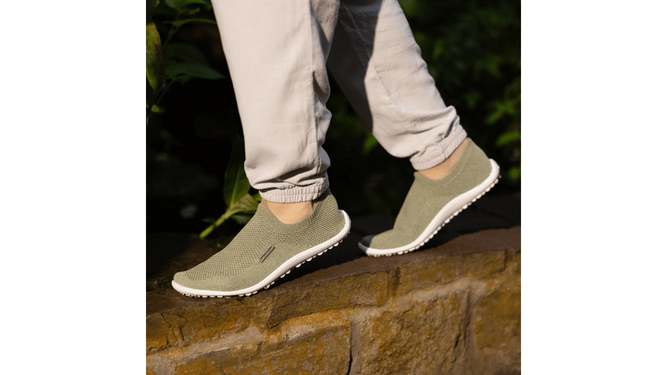 Barfußschuh mit geschlossener Zehenbox und geschlossenem Fersenbereich, elastischer Einstieg ohne Verschluss, flexible profilierte Sohle, schräge Vorderansicht am Fuß getragen