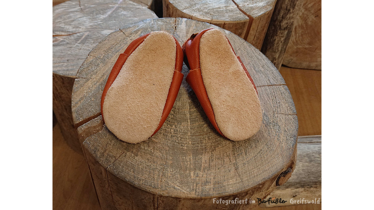 Barfußhausschuh für Kinder mit geschlossener Zehenbox und geschlossenem Fersenbereich, elastischer Einstieg ohne Verschluss, flexible Sohle, Ansicht von unten als Paar