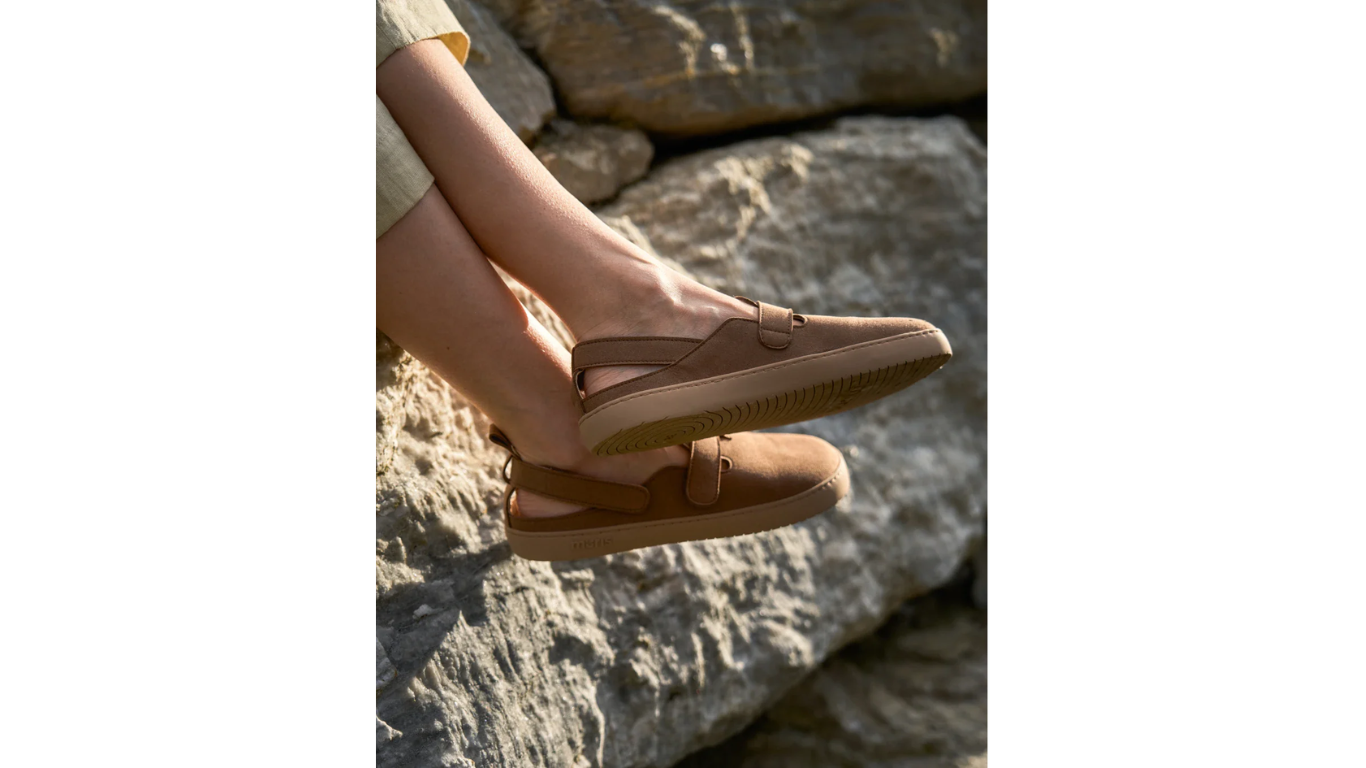 Kind trägt Barfußschuhe mit Riemen und geschlossener Zehenpartie im Außenbereich, Detailansicht.
Hinweis: Lifestylebild, kein reines Produktbild