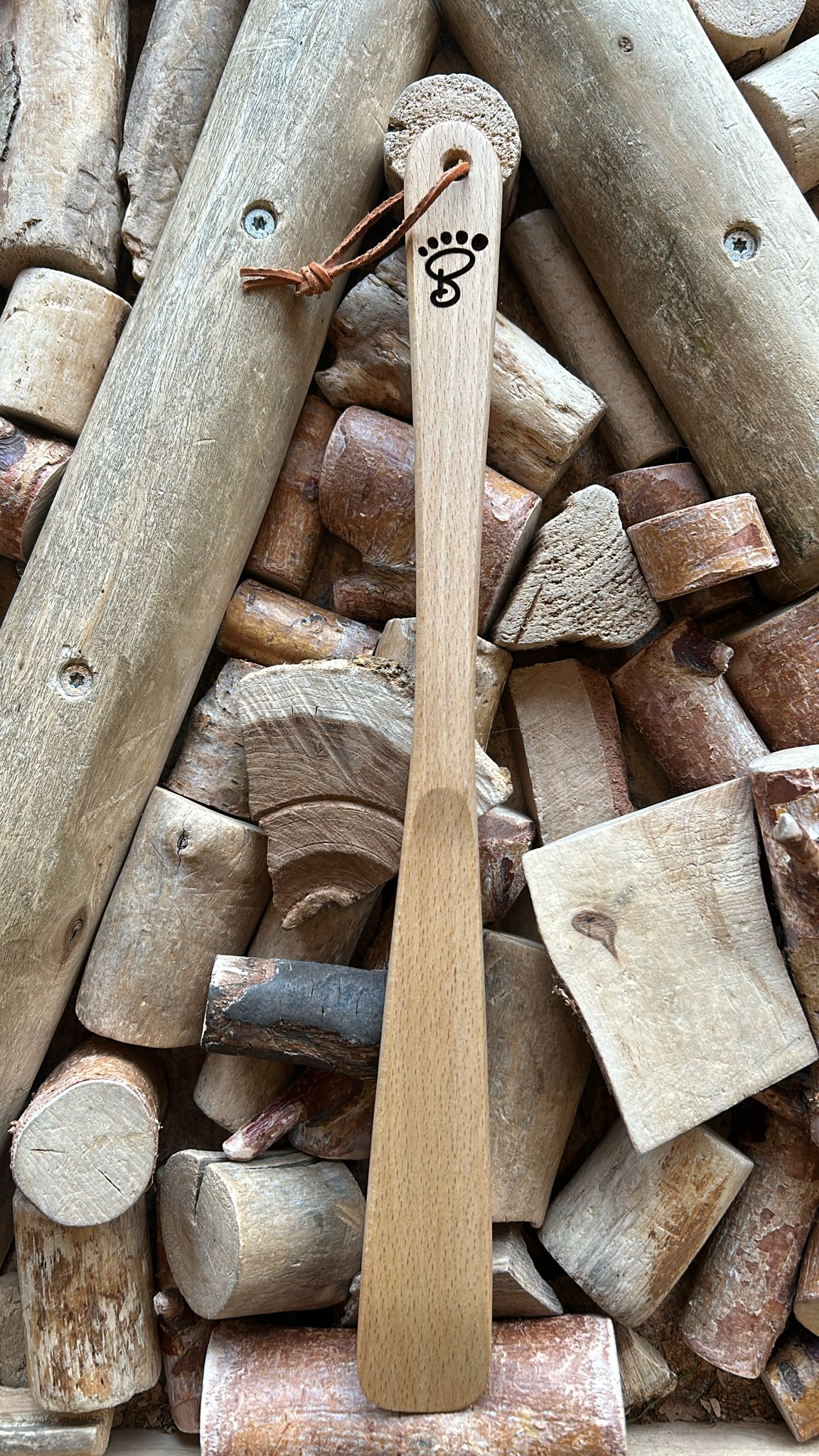 Schuhanzieher aus Holz mit Griffloch und Schlaufe, längliche Form, Detailansicht.