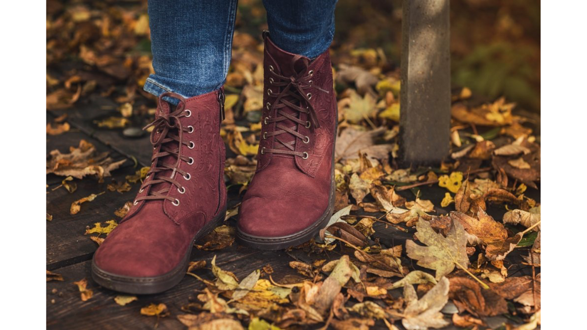 Barfußstiefel mit Schnürverschluss am Fuß getragen, breiter Zehenbox und flacher Sohle, geschlossener Fersenbereich, schräge Vorderansicht