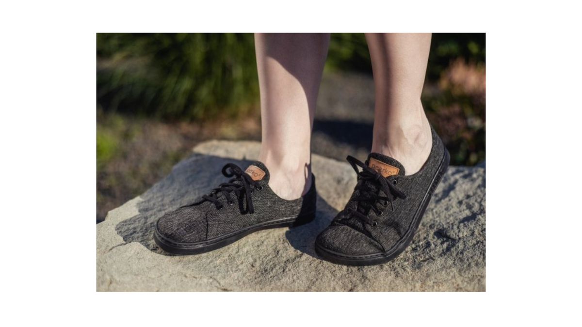 Barfußschuh am Fuß getragen mit Schnürverschluss, breiter Zehenbox und flacher Sohle, geschlossener Fersenbereich, schräge Vorderansicht