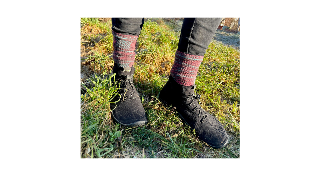 Barfußschuh für Erwachsene, geschlossene Zehenpartie, geschlossener Fersenbereich, hoher gestrickter Schaft, Schnürung mit Schnellverschluss, flache Sohle, schräge Vorderansicht als Paar, getragen am Fuß