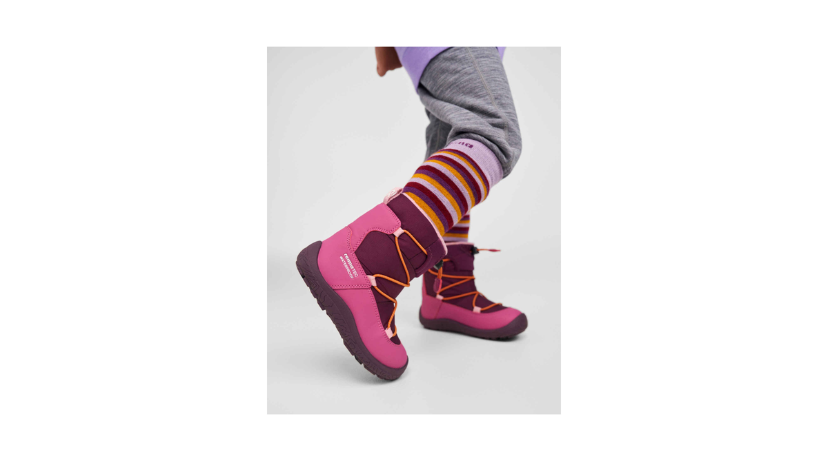 Kinder-Barfußwinterstiefel mit Schnellverschluss und Profilsohle am Fuß getragen, Seitenansicht außen