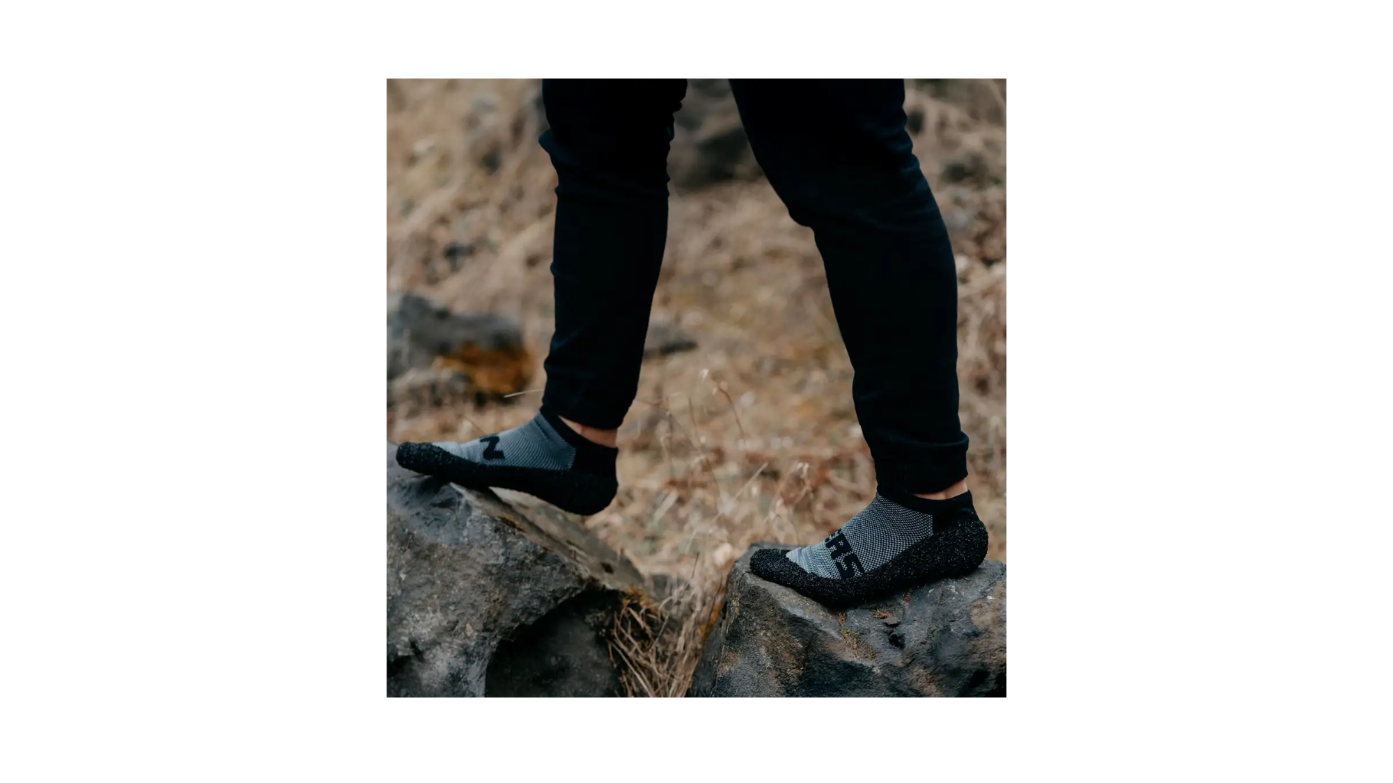 Skinners Socken in concrete, getragen auf unebenem Untergrund, flexible Sohle und bodennahes Laufgefühl.