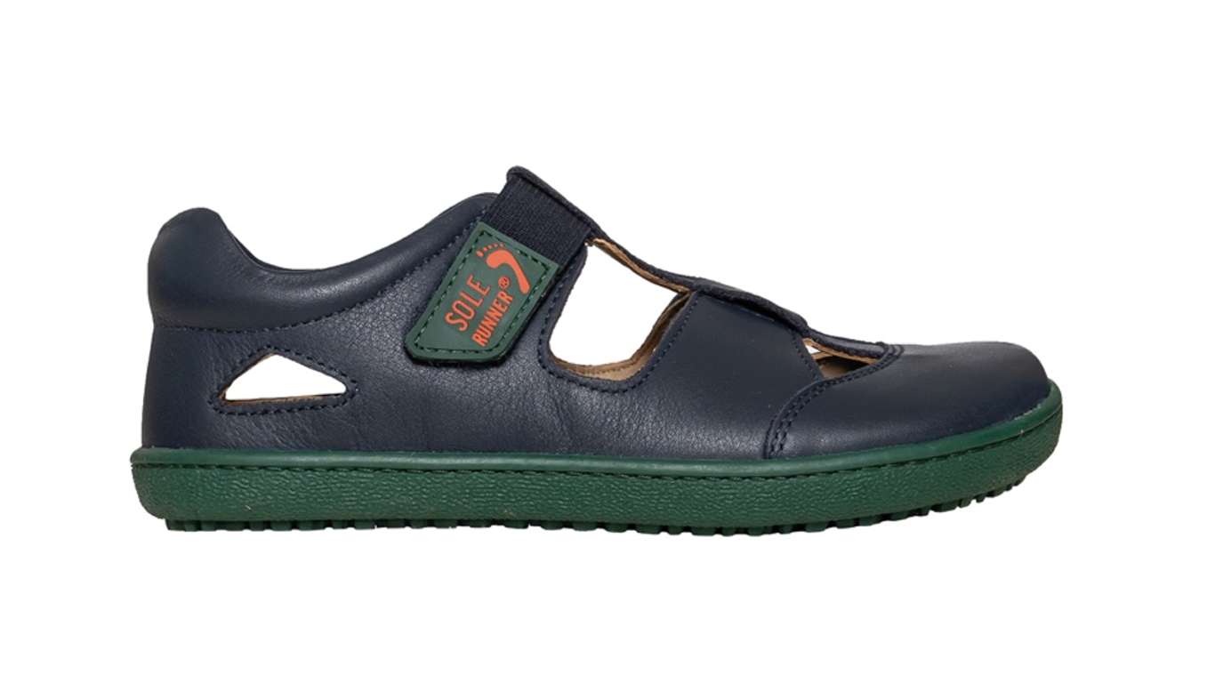 Kinder Barfußsandale, geschlossene Zehen und geschlossener Fersenbereich, zwei Klettverschlüsse und Riemen, flexible Sohle, einzelner Schuh, Seitenansicht außen