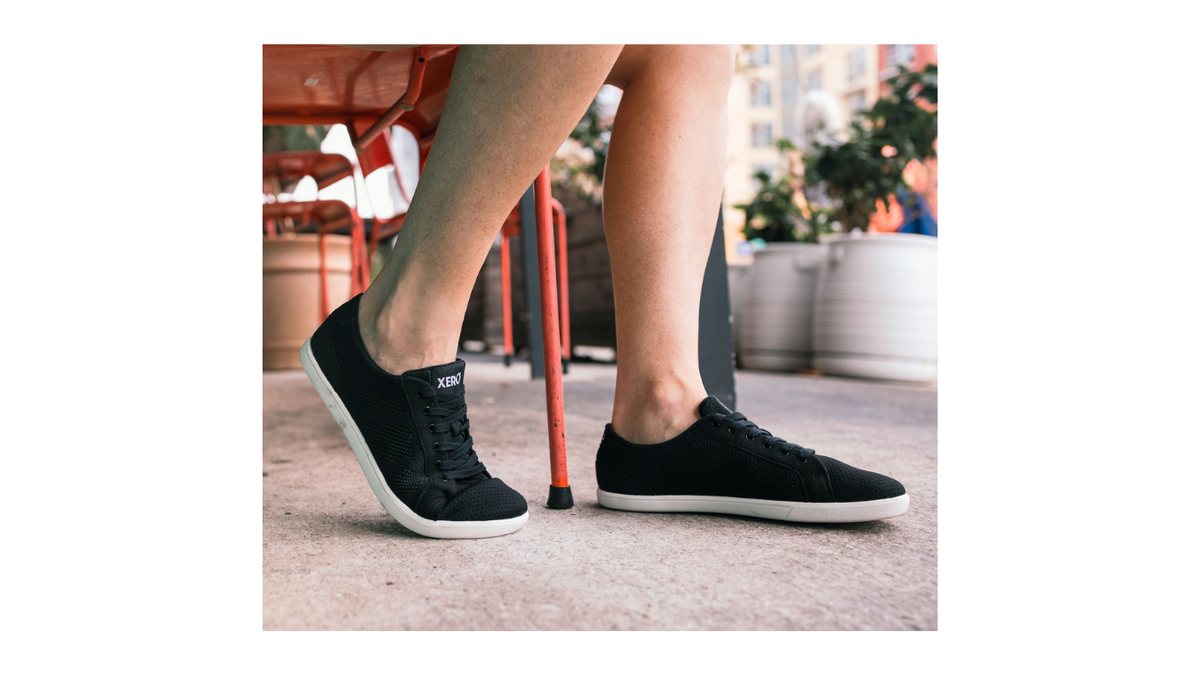 Barfußschuh mit Schnürung, breite Zehenbox, flexible Sohle, geschlossener Fersenbereich, schräge Vorderansicht als Paar, am Fuß getragen