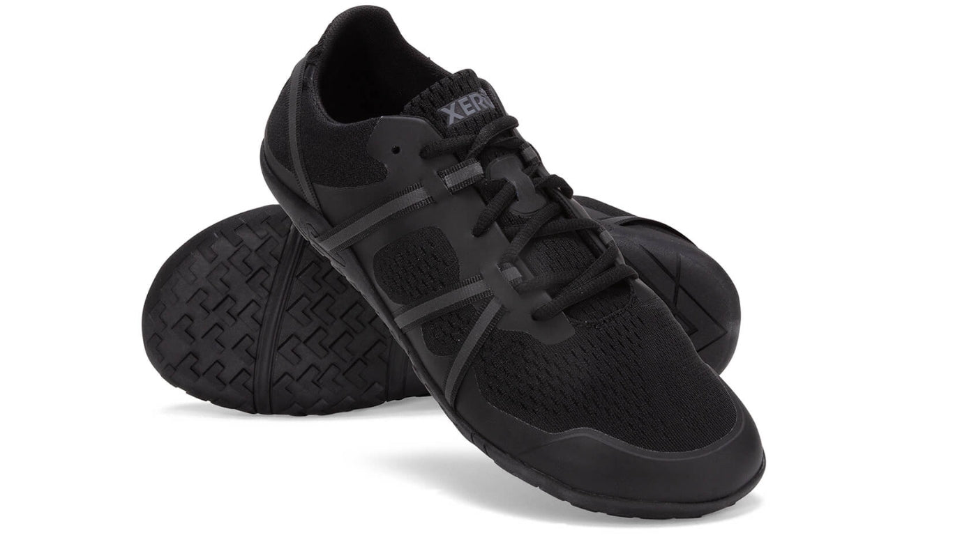 Barfußsportschuh für Erwachsene als Paar, breite Zehenbox, geschlossene Zehen, geschlossener Fersenbereich, Schnürung, schräge Vorderansicht.