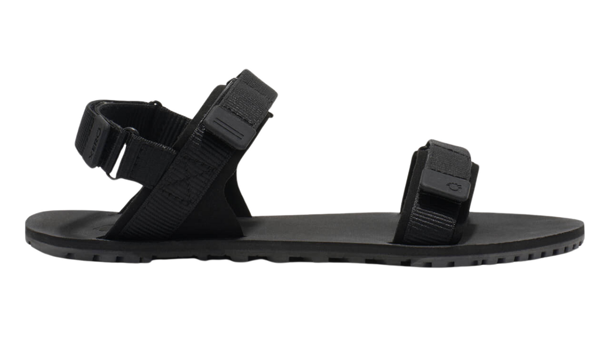 Barfußsandale für Erwachsene als einzelner Schuh, offene Zehen, offener Fersenbereich, Riemenkonstruktion mit Klettverschluss, Seitenansicht außen.