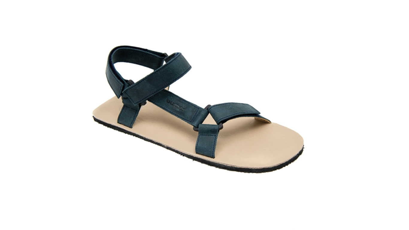Barfußsandale für Erwachsene als einzelner Schuh, offene Zehen, offener Fersenbereich, Riemenkonstruktion mit Klettverschluss, schräge Vorderansicht.