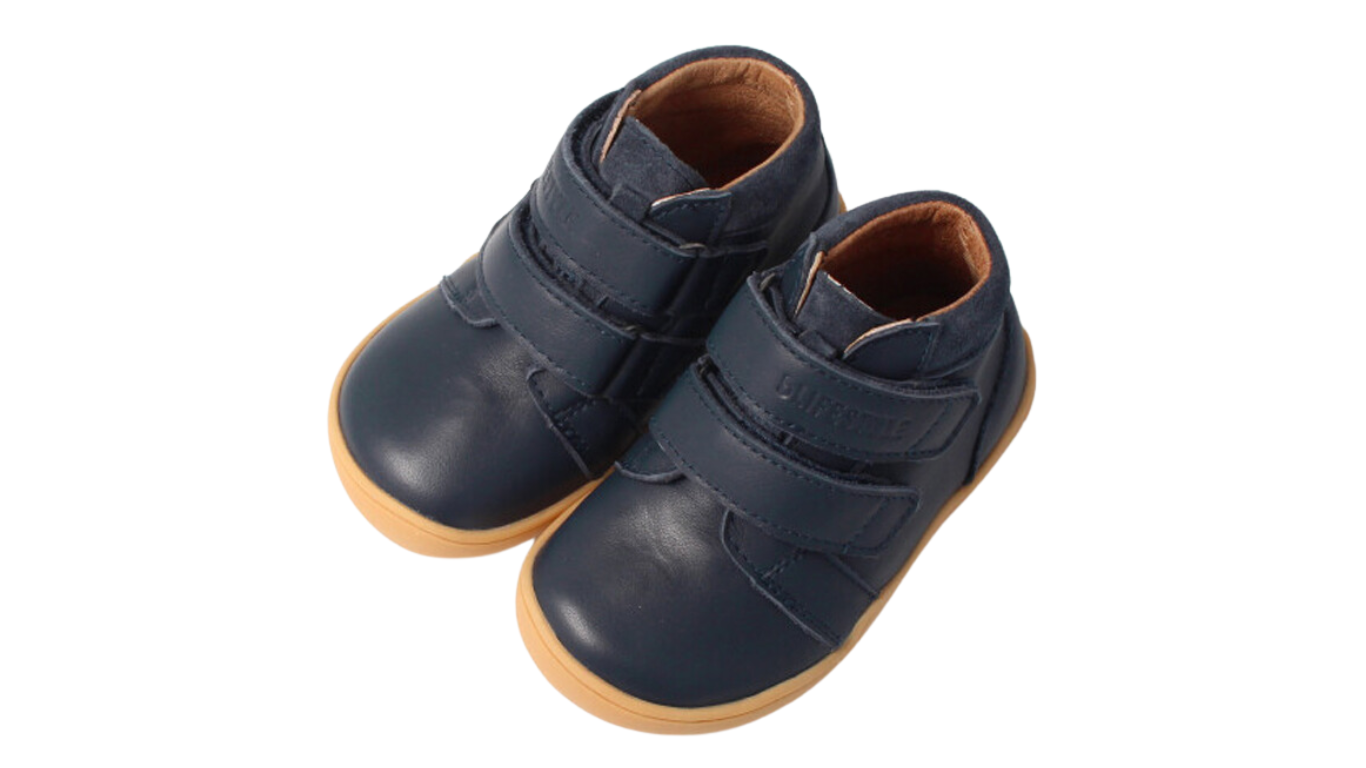 Knöchelhoher Barfußschuh für Kinder mit breiter Zehenbox, Klettverschluss, geschlossenen Zehen, geschlossenem Fersenbereich, schräge Vorderansicht als Paar. 