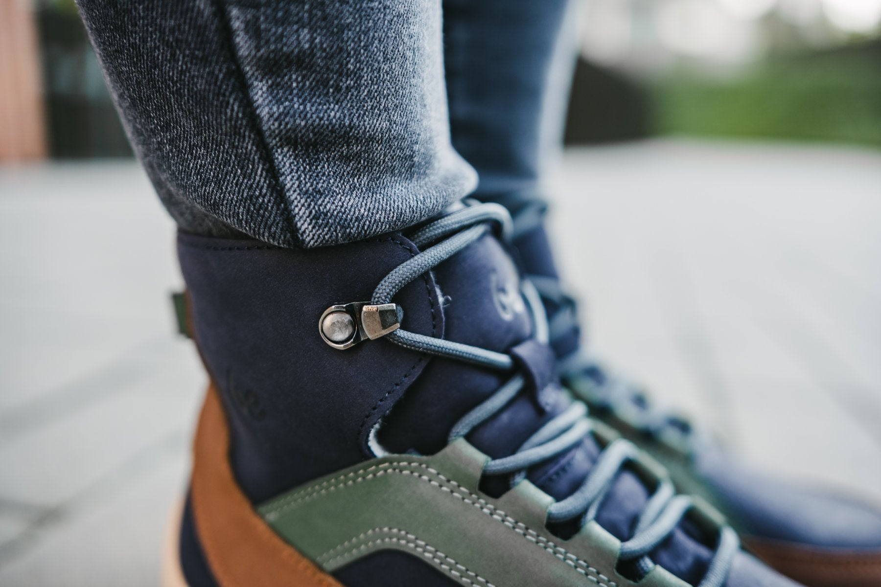 Barfußwinterstiefel für Erwachsene am Fuß getragen mit Schnürung und knöchelhohem Schaft, Detailansicht.