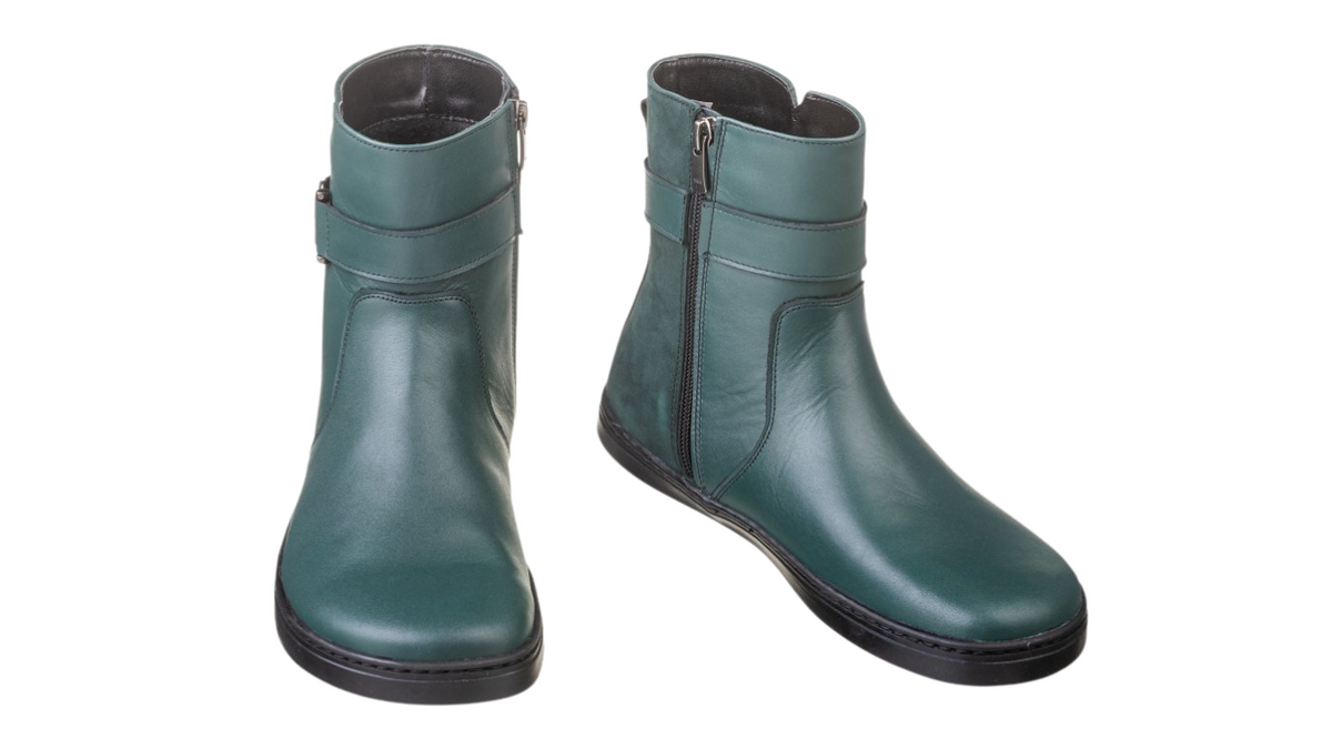 Barfußstiefel als Paar mit seitlichem Reißverschluss und Riemen, breiter Zehenbox und flacher Sohle, geschlossener Fersenbereich, schräge Vorderansicht
