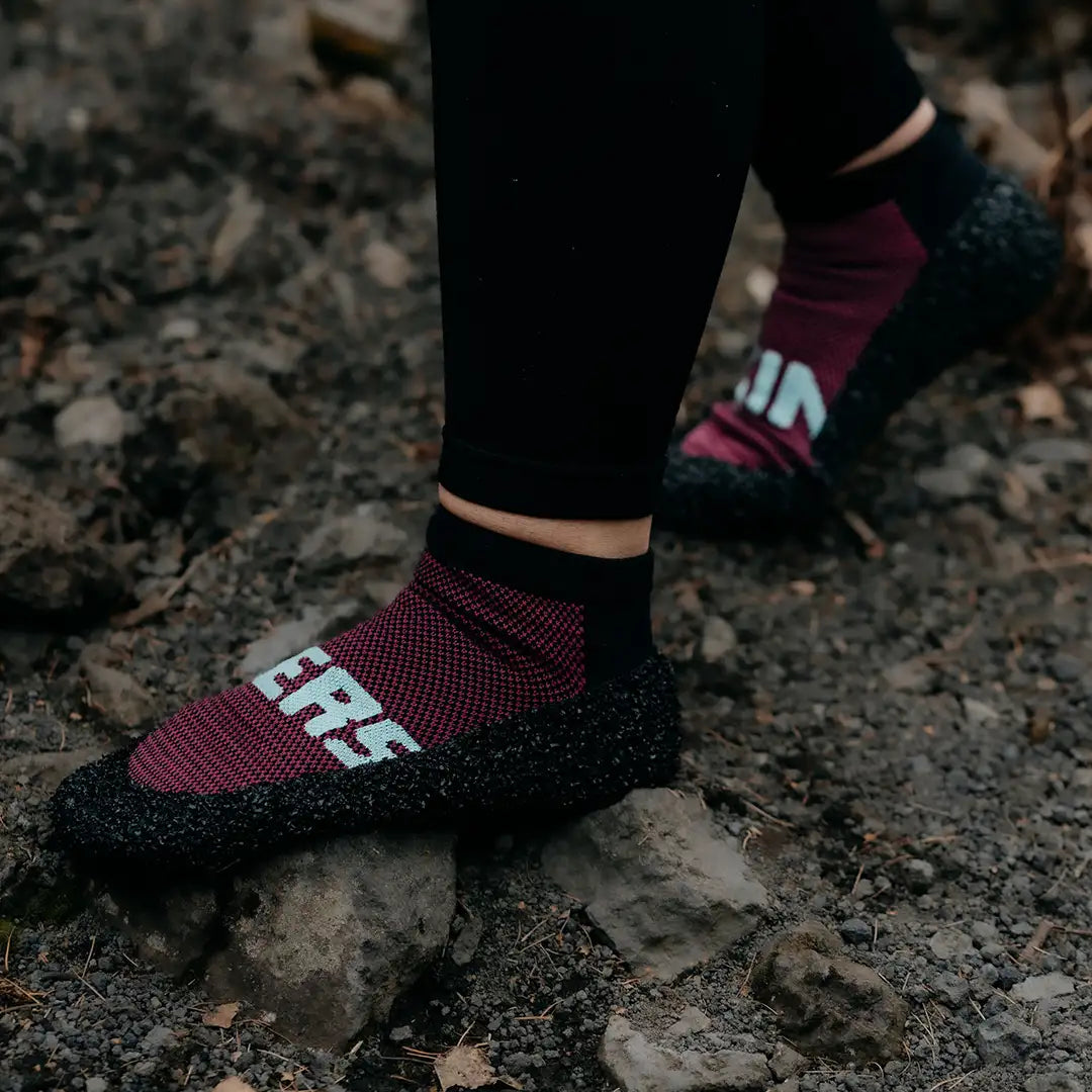 Skinners Socken in Bordeaux, getragen auf unebenem Untergrund, flexible Sohle und bodennahes Laufgefühl.