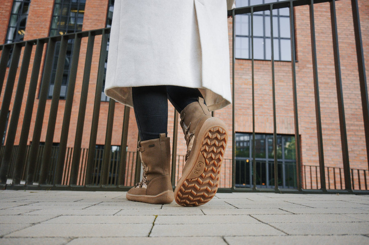 Barfußwinterstiefel für Erwachsene am Fuß getragen mit profilierter, flexibler Sohle, Ansicht von unten.